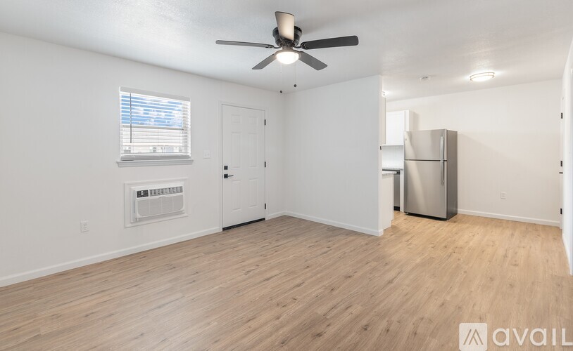 A room with a ceiling fan and a window with blinds.