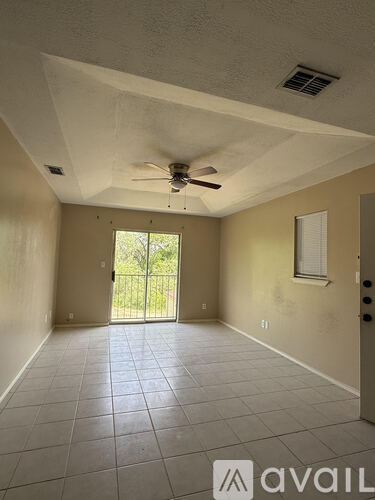A room with a ceiling fan and tile flooring.