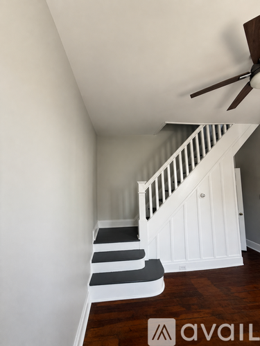 A staircase with a white railing and black steps.