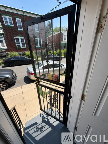 A black gate with a white door in front of a brick building.