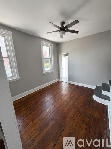 A room with wooden floors and a ceiling fan.