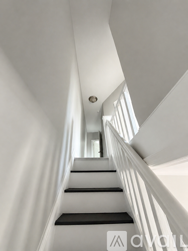 A staircase with a white railing and black steps.