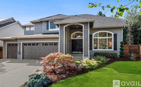 A house with a grey roof and a garage door.