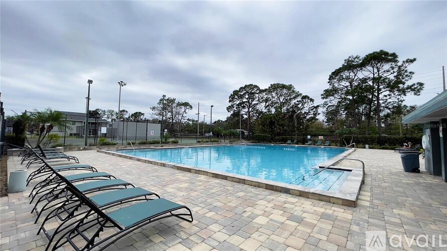 A pool surrounded by trees and a cloudy sky.