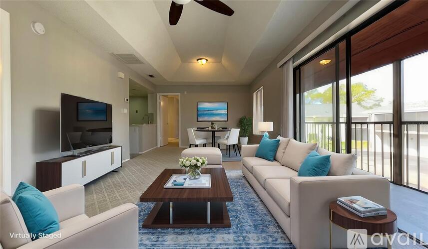 A living room with a white couch, a coffee table, and a flat screen TV.