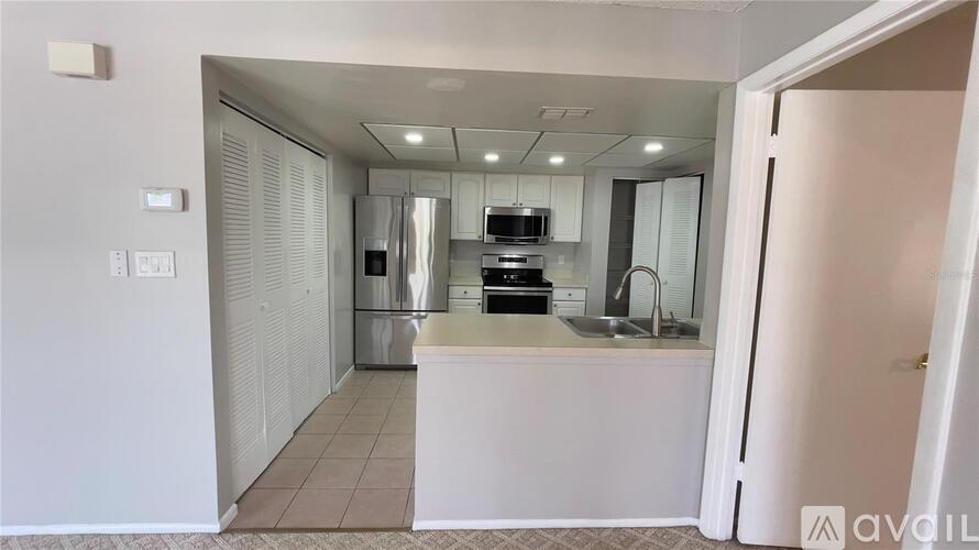 A kitchen area with white cabinets and a countertop.