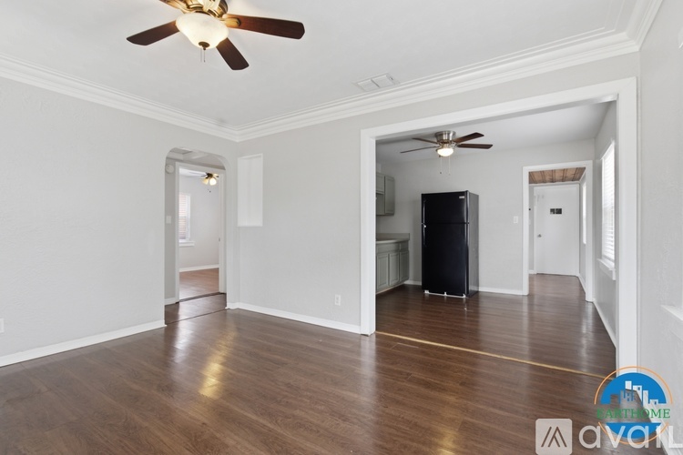 A spacious room with a ceiling fan and a black television set.