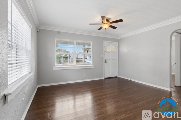 A room with a ceiling fan and a window with blinds.