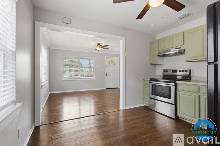 A kitchen with a refrigerator, oven, and stove top.