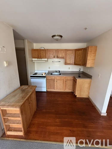 A kitchen with wooden cabinets and a white oven.