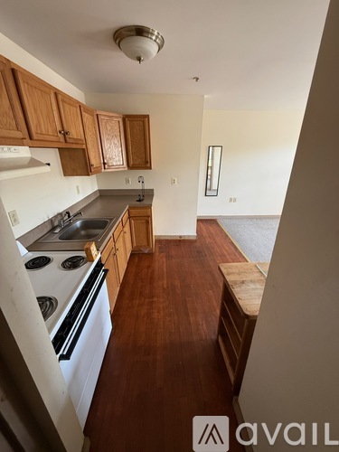 A kitchen with wooden cabinets and a white stove top oven.