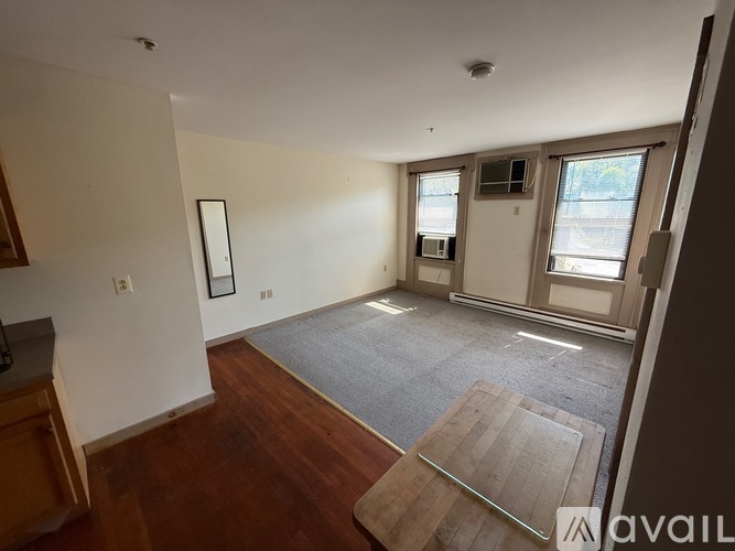 A room with a grey carpet and wooden floors.