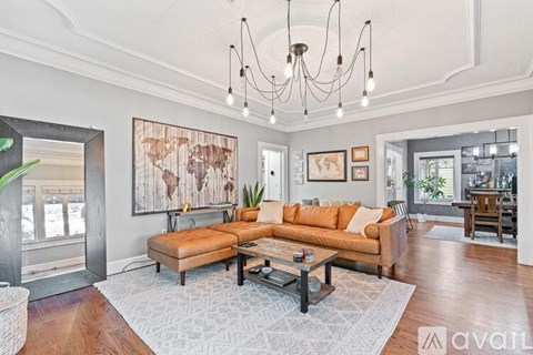 A living room with a large sectional sofa and a coffee table in the center.