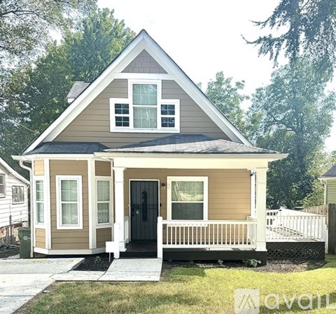 A small house with a black door and a porch.