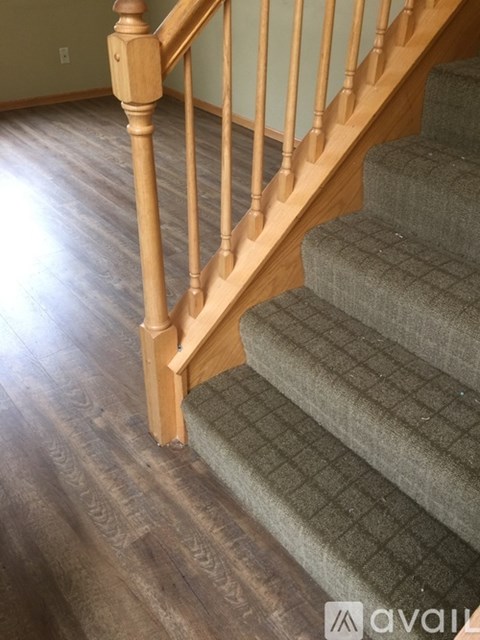 A wooden staircase with a carpeted runner.