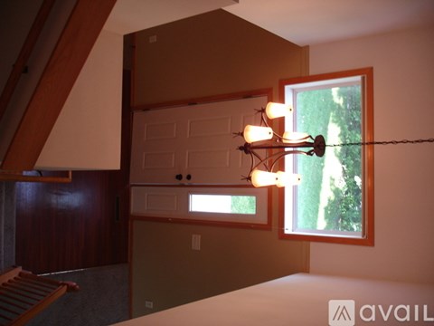 A bedroom with a bed, a window, and a chandelier.