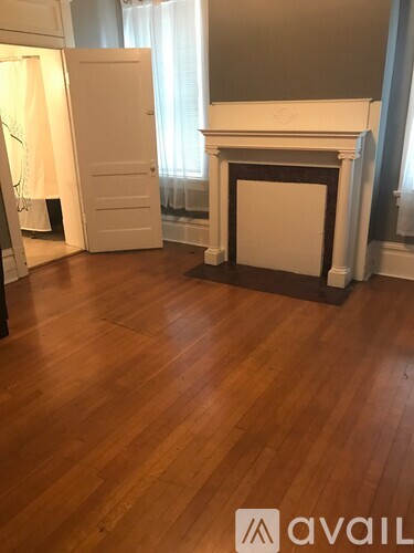A room with a fireplace and wooden floors.