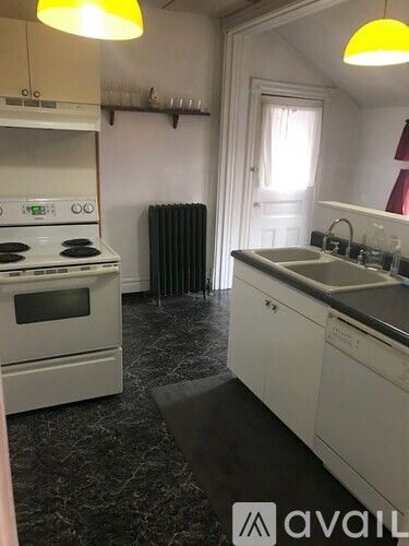 A kitchen with a white stove and white cabinets.