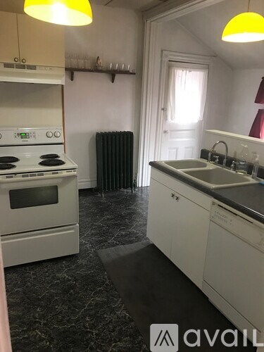 A kitchen with a white stove and white cabinets.