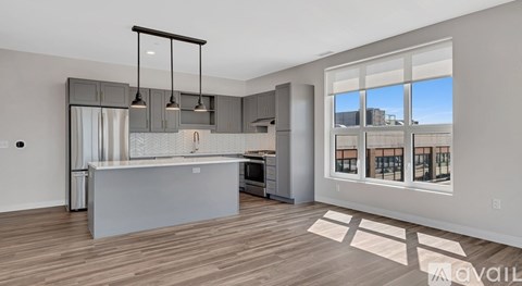 A modern kitchen with wooden floors and a large island.