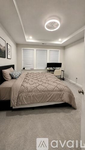 A bedroom with a bed, nightstand, and window with blinds.