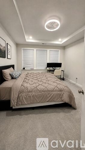 A bedroom with a bed, nightstand, and window with blinds.