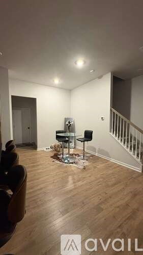 A living room with a black chair and a small table with a black chair.
