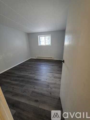 A room with wooden flooring and a window.