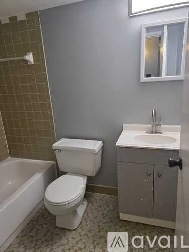 A white toilet sits next to a bathtub in a bathroom.