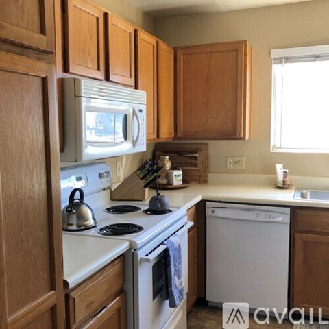 A kitchen with wooden cabinets and white appliances.