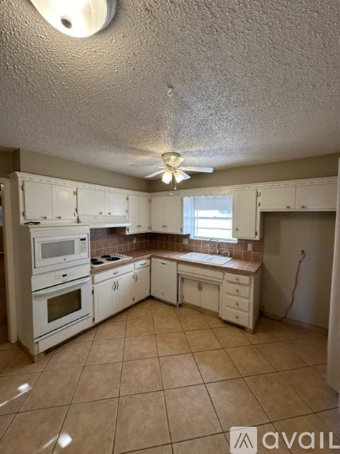 A kitchen with white appliances and cabinets.