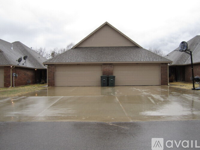 A large garage with a brown roof and a grey wall is available for rent.