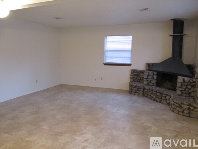 A room with a stone fireplace and a window.