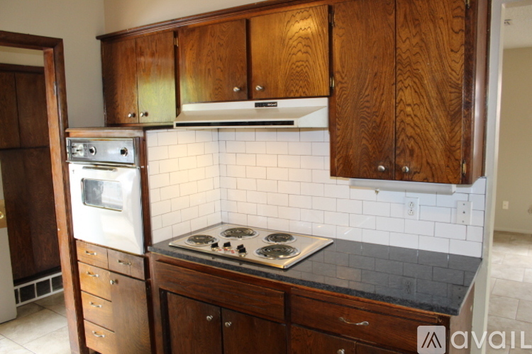 A kitchen with wooden cabinets and a stove top oven.