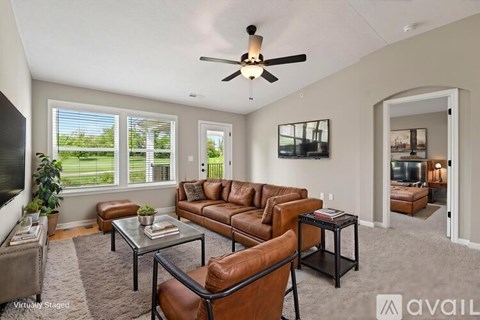 A living room with a brown leather couch and a glass coffee table.