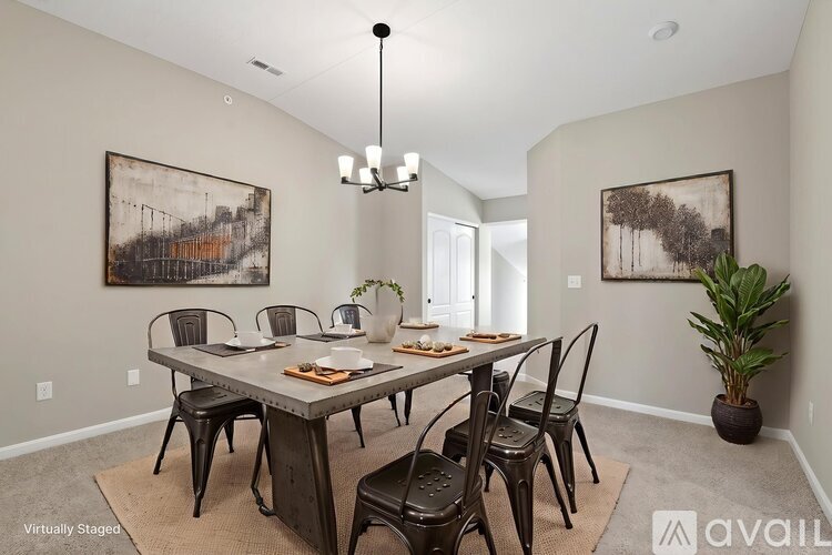 A dining room with a table set for six and two framed pictures on the wall.