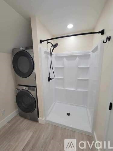 A white door with a black handle is in a room with a washing machine and dryer.