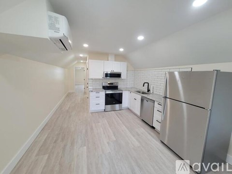 A kitchen with a refrigerator, stove, and cabinets.