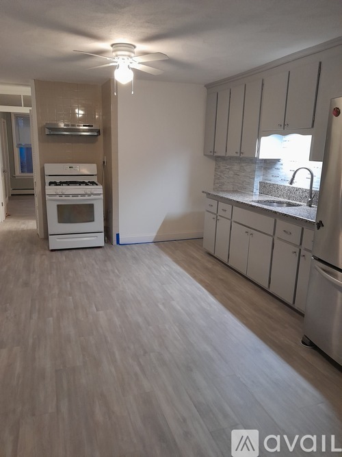 A kitchen with white appliances and cabinets.