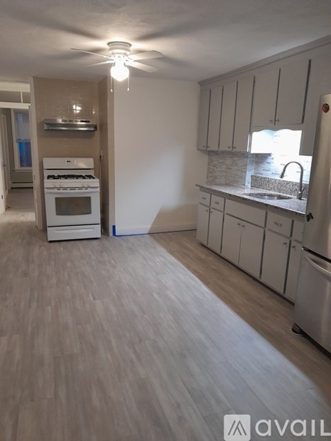 A kitchen with white appliances and cabinets.