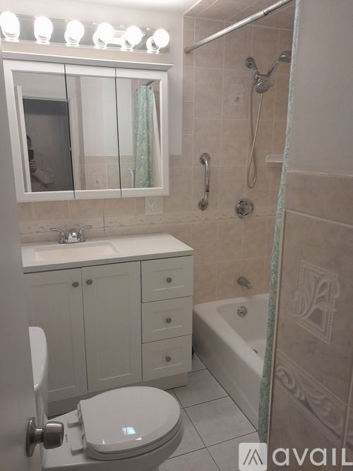 A bathroom with a toilet, sink, and shower.