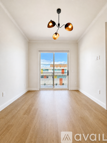 A room with a large window and a balcony overlooking a building.