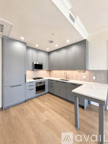 A kitchen with a white countertop and grey cabinets.