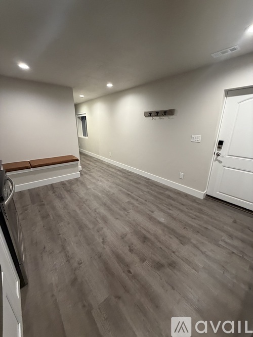 A room with a white door and a wooden floor.