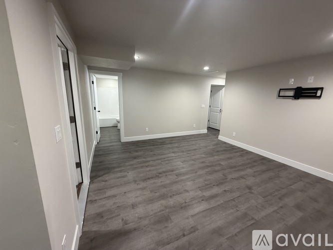 A spacious room with grey flooring and white walls.