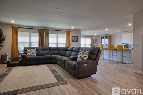 A living room with a large sectional sofa and a rug in the foreground.