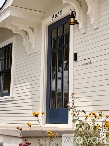 A white house with a dark blue door and windows.