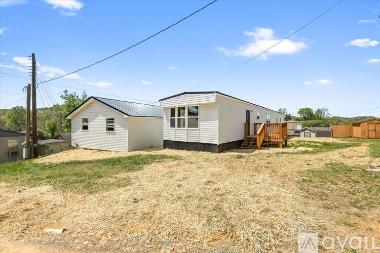 A house with a metal roof is surrounded by a grassy area.