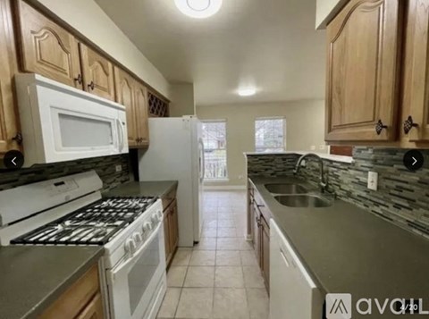 A kitchen with a white stove top oven and a white microwave.
