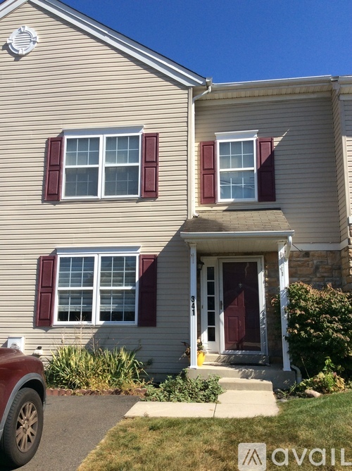 A house with a red car parked in front.